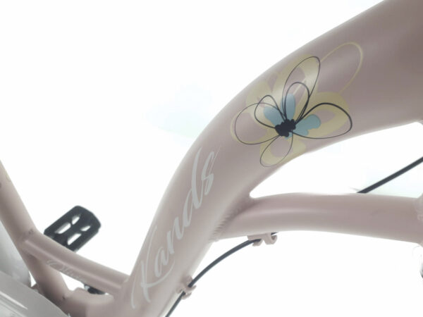 Rosa cykelram med fjärilmotiv och inskription.