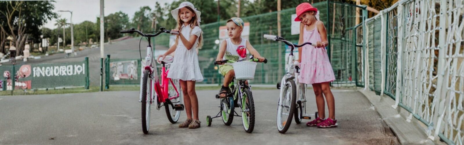 Tre barn cyklar och leker utomhus